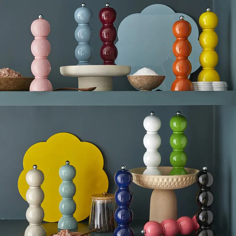 De nombreux Addison Ross de couleurs variées (rose, bleu, mink, orange, jaune, vert, marine, etc) décorants des étagères d'un gris bleuté