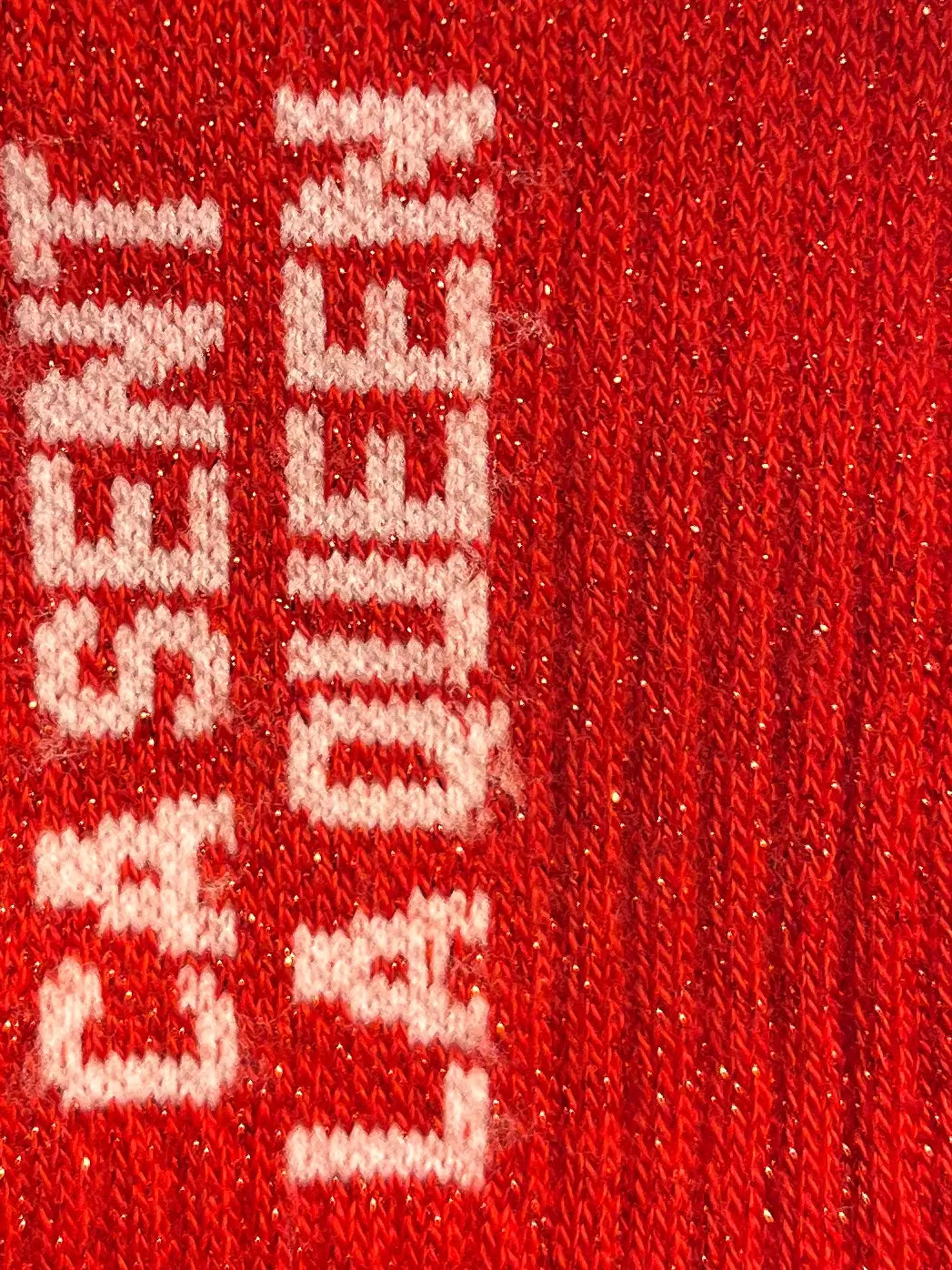 Focus sur la chaussette Félicie cousue en coton, rouge à paillettes avec « ça sent la queen » écris en blanc