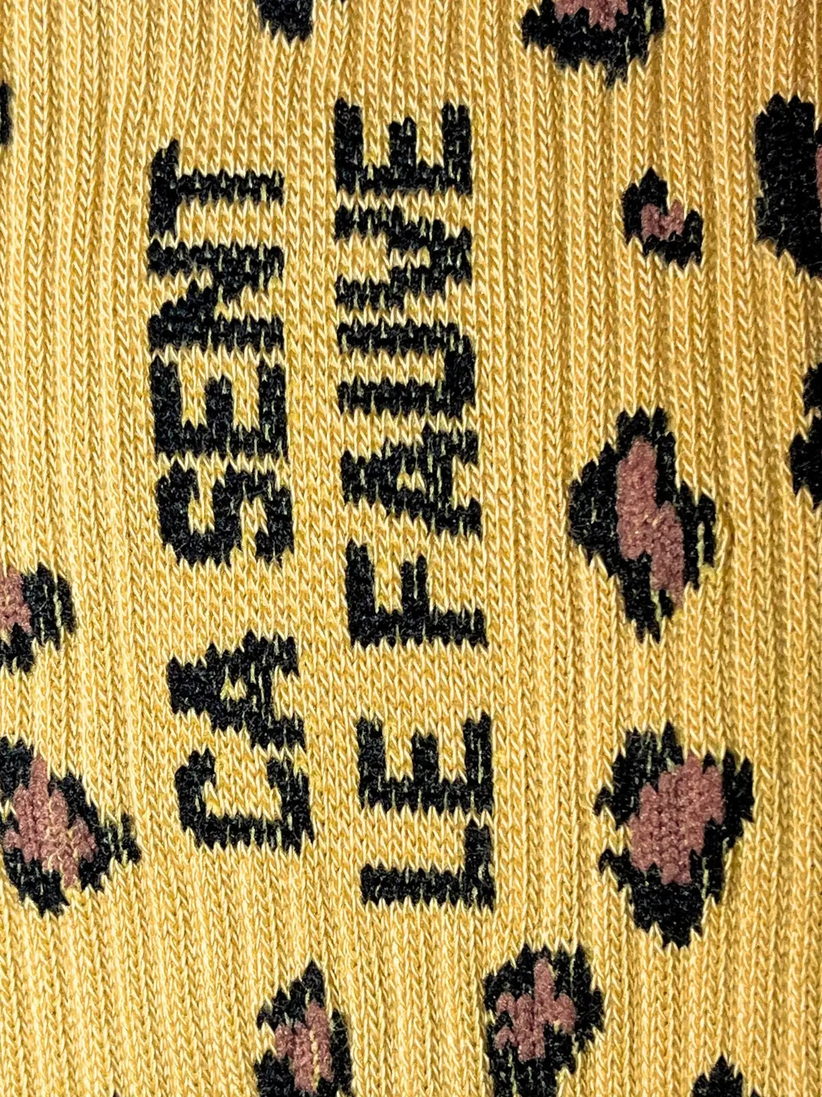 Focus sur le message de la chaussettes léopard Félicie Aussi « ça sent le fauve » écrit en noir