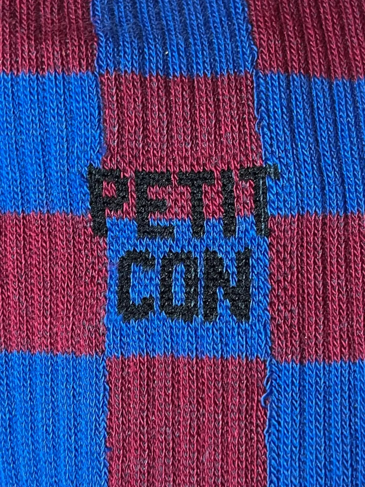 Focus sur la chaussette Félicie cousue en coton, bleu bordeaux avec « petit con » écrit en noir