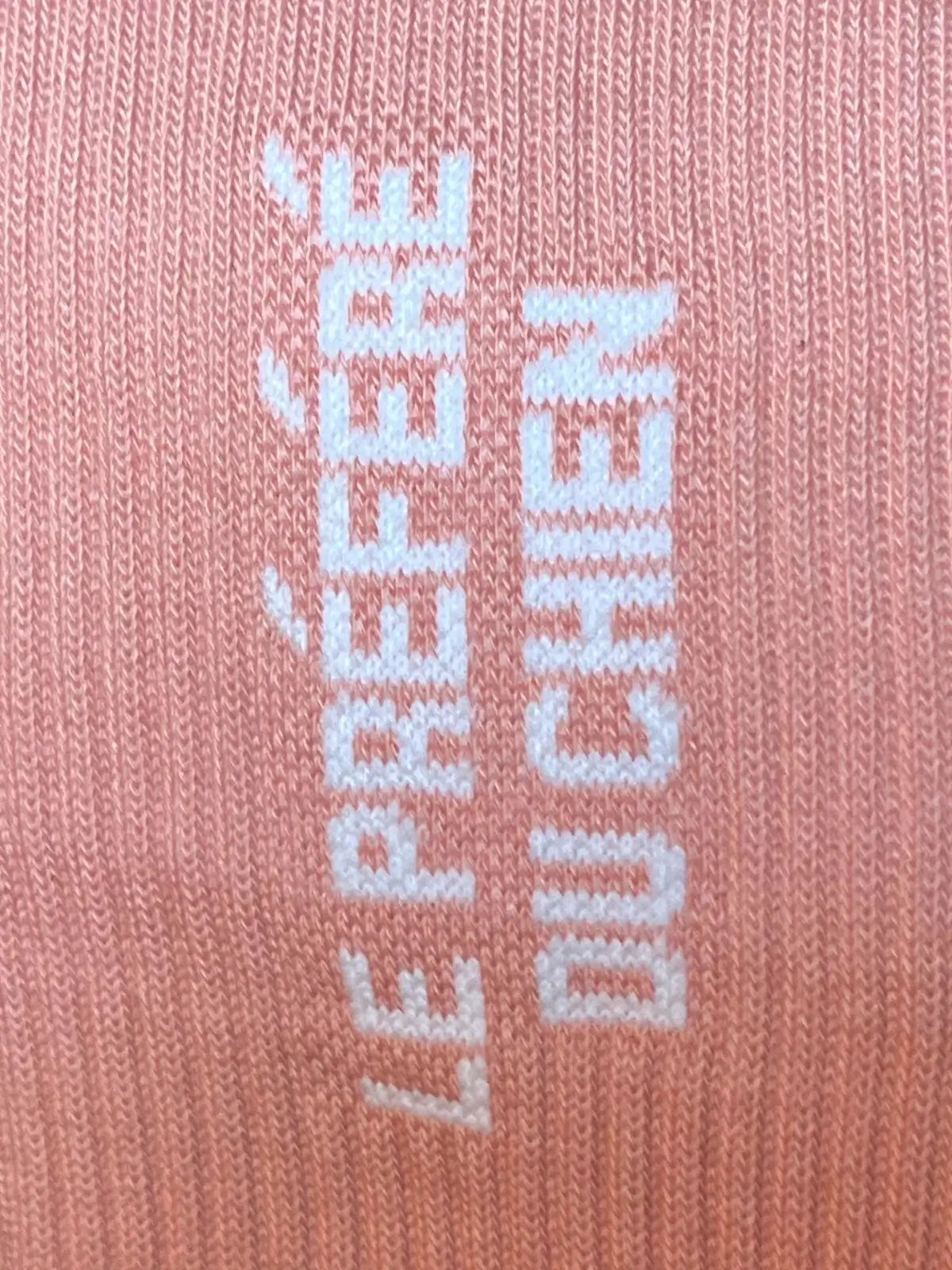 Focus sur la chaussette Félicie cousue en coton, rose saumon avec « le préféré du chien » écrit en blanc