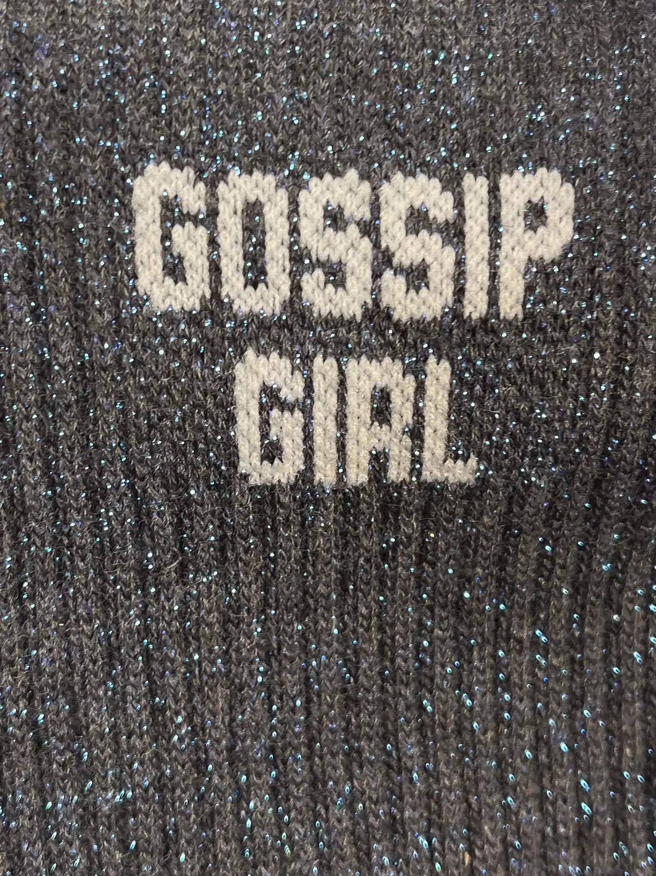 Focus sur la chaussette Félicie cousue en coton, grise à paillettes avec « Gossip Girl » écris en blanc
