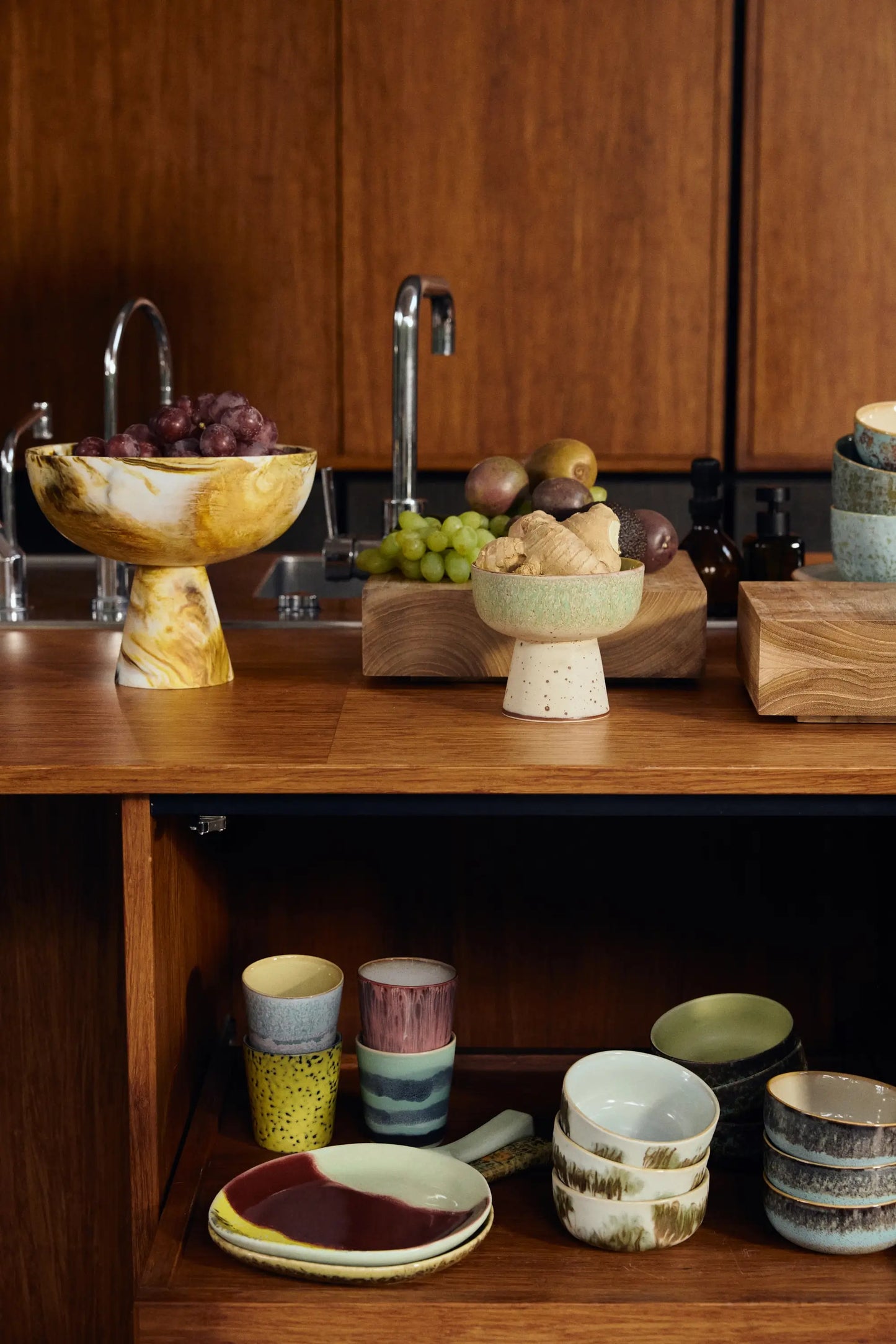 Vaisselle en céramique dont tasses à café Artistic dans une cuisine en bois