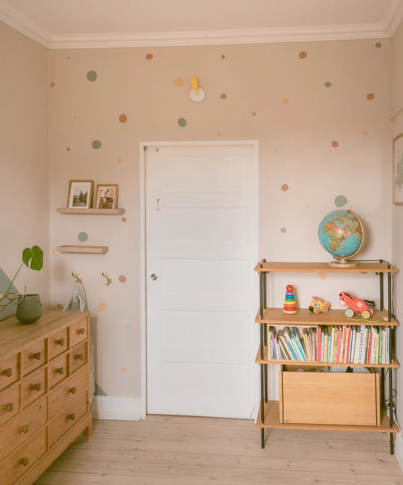 Birdie, capteur mural de CO₂ en forme d’oiseau jaune, présenté sur un mur dans une chambre d'enfant