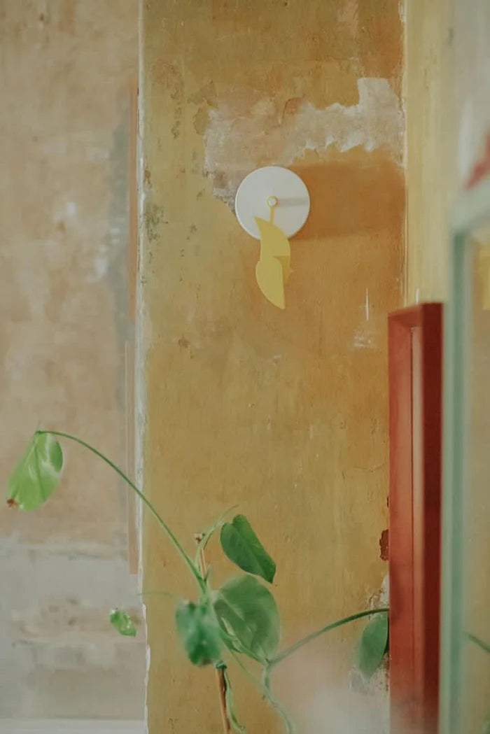 Birdie, capteur mural de CO₂ en forme d’oiseau jaune, présenté sur un mur tête en bas