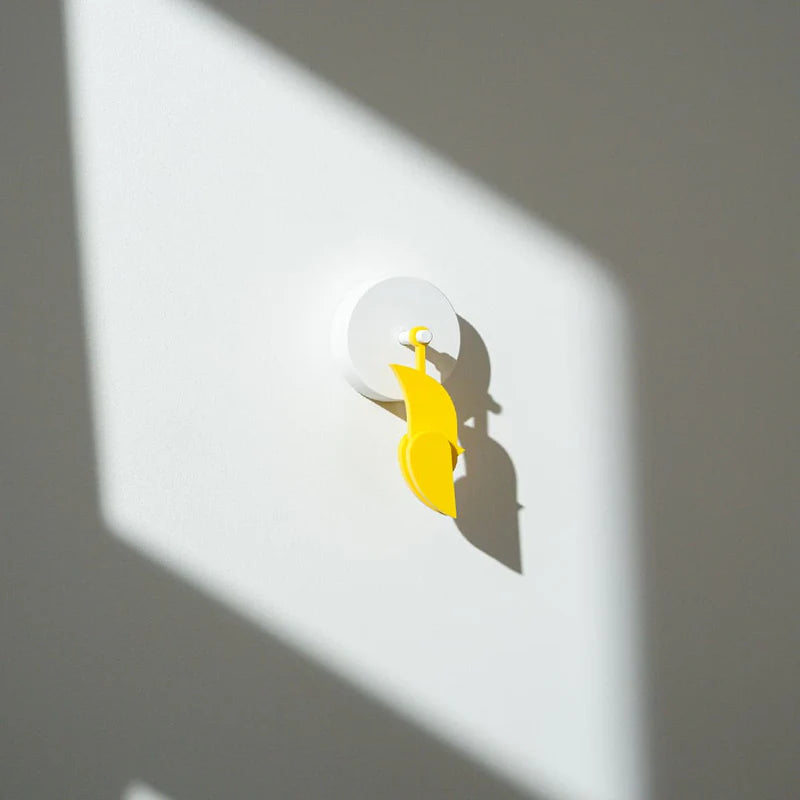 Birdie, capteur mural de CO₂ en forme d’oiseau jaune, présenté sur un mur tête en bas