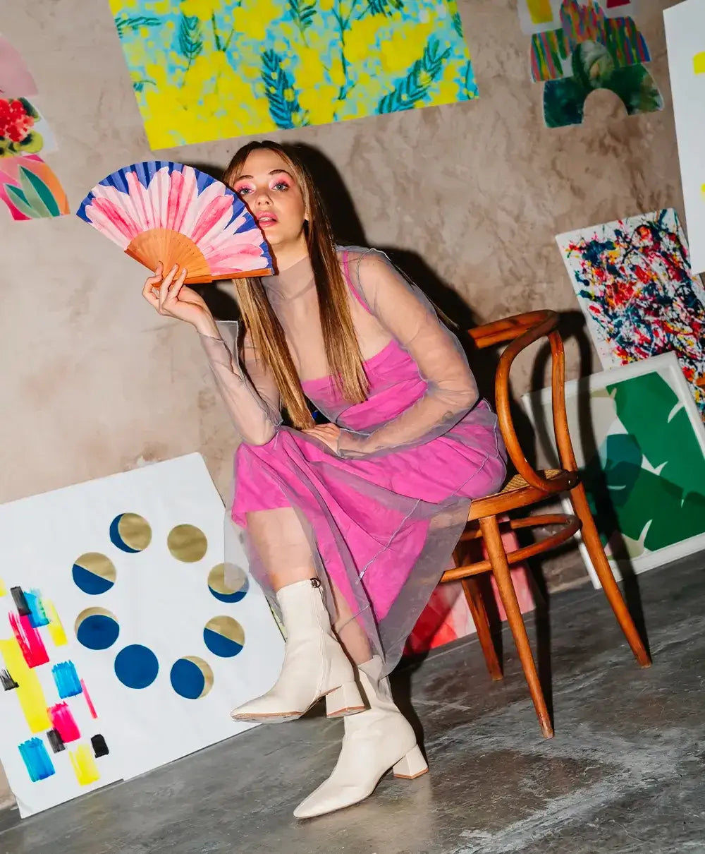 Éventail Pink Power tenu en main dans un atelier d'artiste