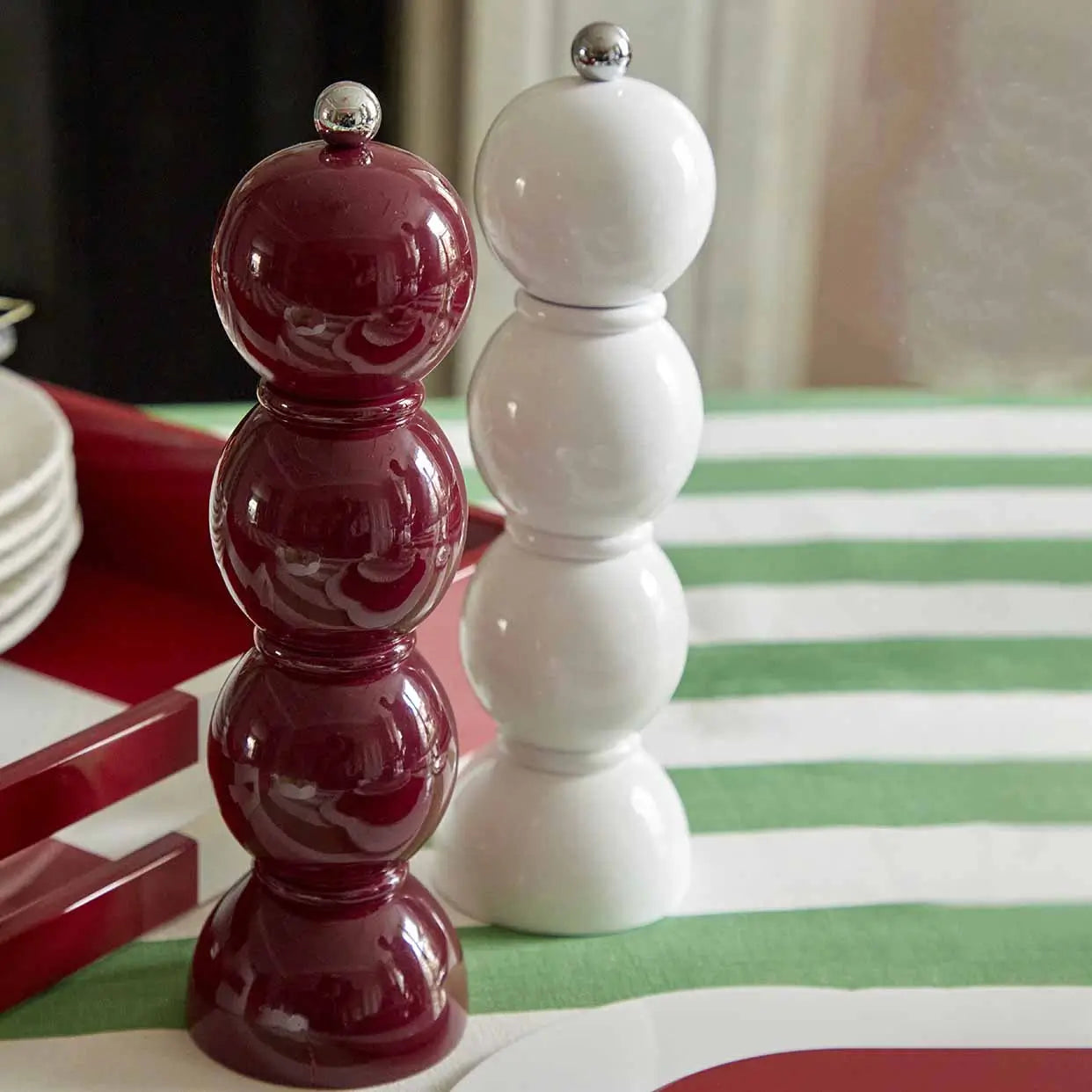 Moulins à poivre et sel Bobbin de 24 cm mink et blanc de chez Addison Ross, sur la table d'une salle à manger.