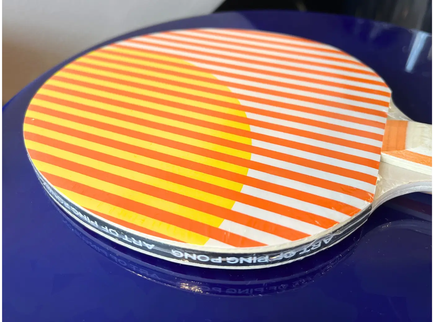 Vue de profil de la raquette Heatwave Art of Ping Pong mettant en valeur son épaisseur et sa finition