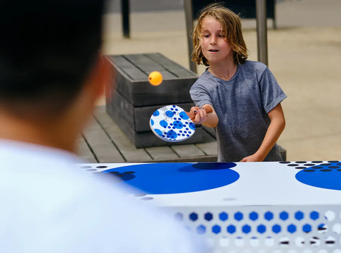 Un père et son fils jouent au ping pong avec les raquettes Triple Spot