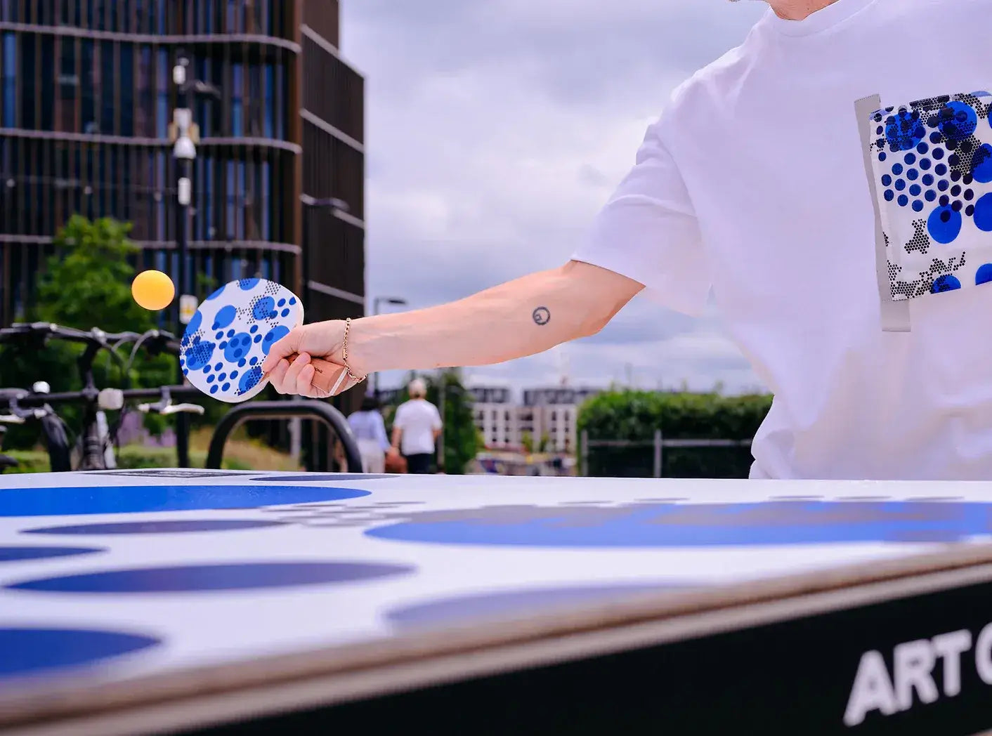 Joueur avec raquette de ping-pong Triple Spot RÆBURN au motif graphique bleu
