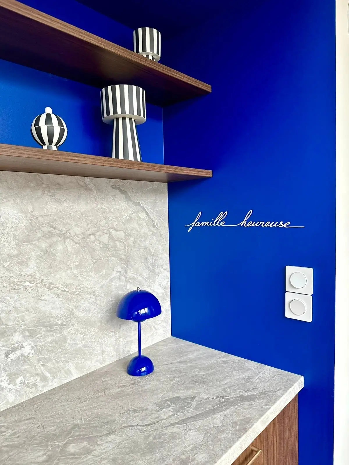 Applique murale "Famille heureuse" par Atelier Suspendu dans une pièce bleue