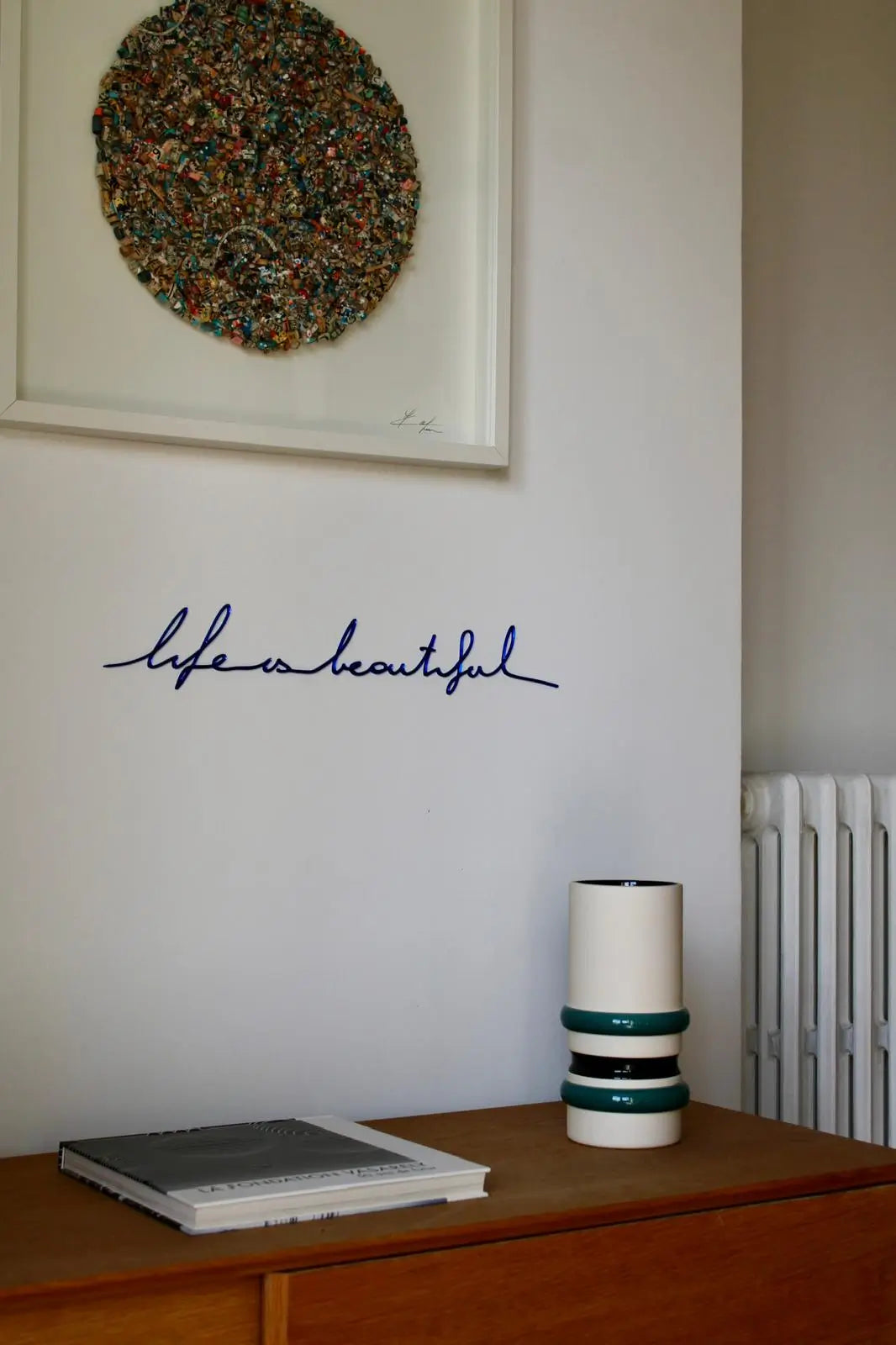 Phrase murale "Life is beautiful" finition bleue dans un couloir