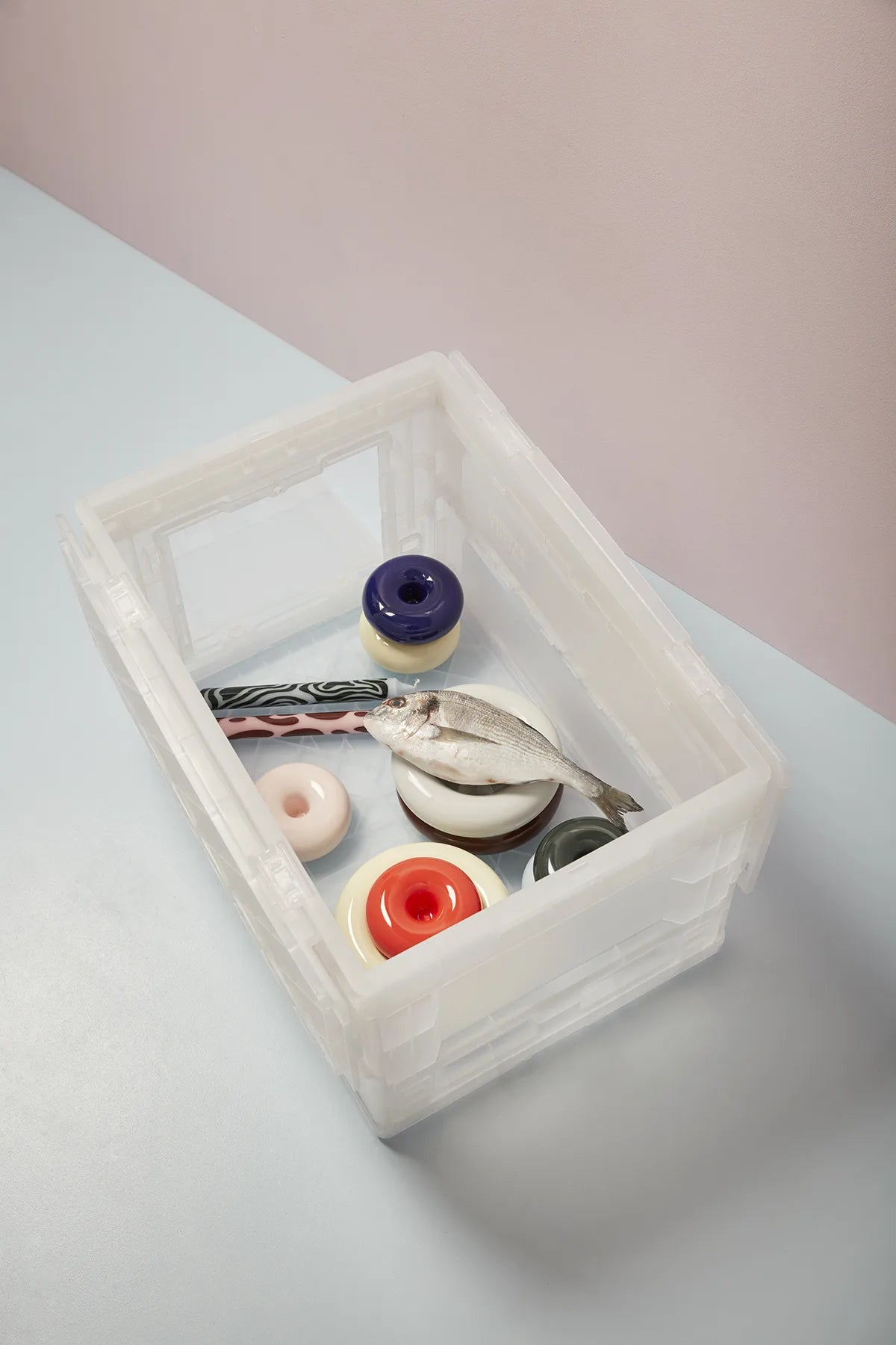 Vue plongeante sur l'intérieur d'une boîte BLOX Small semi-transparente contenant des objets décoratifs