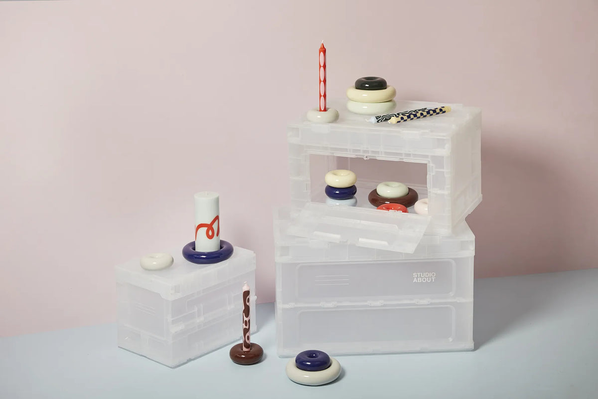 Boîtes de rangement BLOX semi-transparentes Studio About empilées et décorées de bougeoirs et de bougies