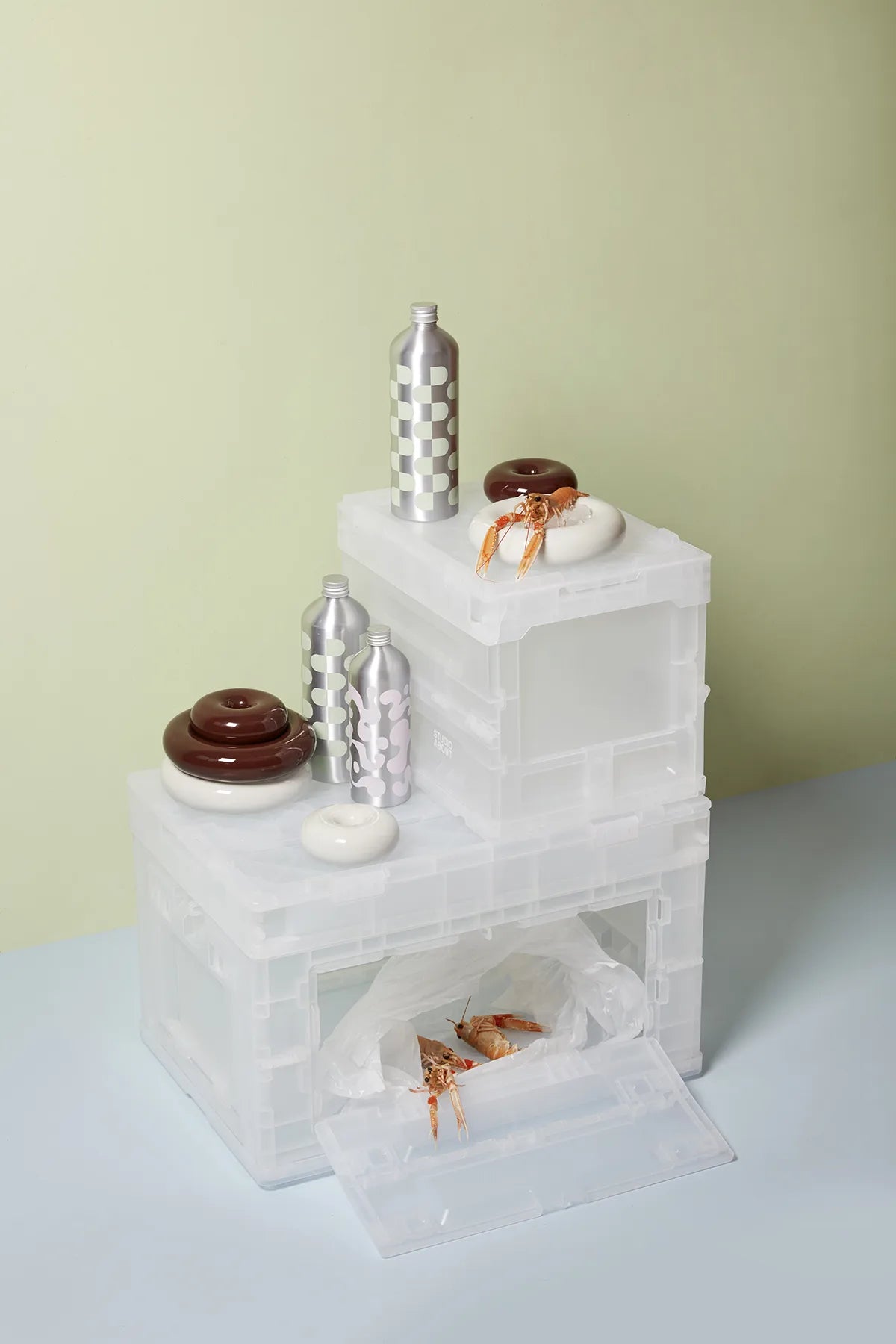Boîtes BLOX semi-transparentes empilées avec bouteilles et objets décoratifs