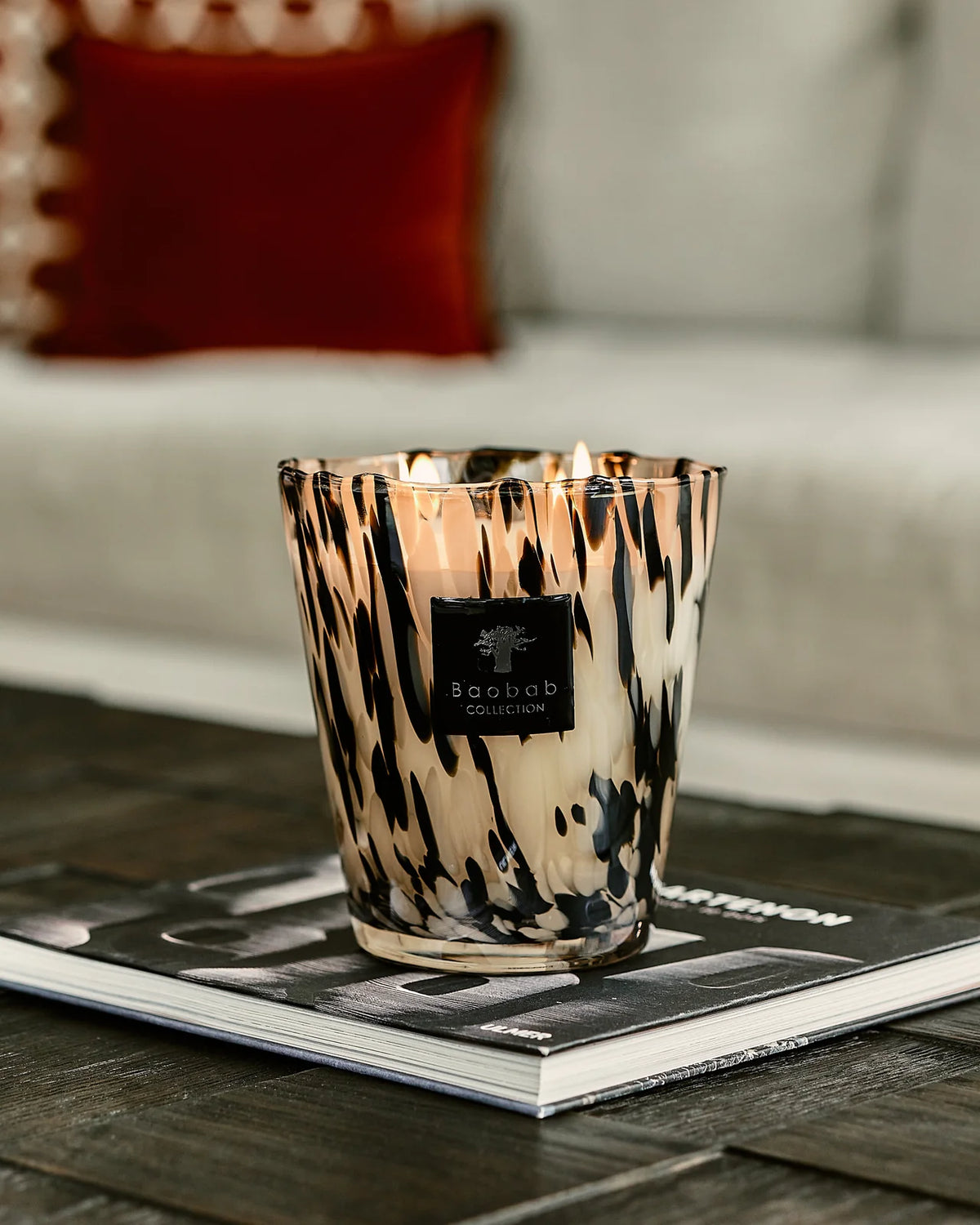 Bougie Black Pearls Baobab Collection révélant les inclusions noires de son verre soufflé bouche
