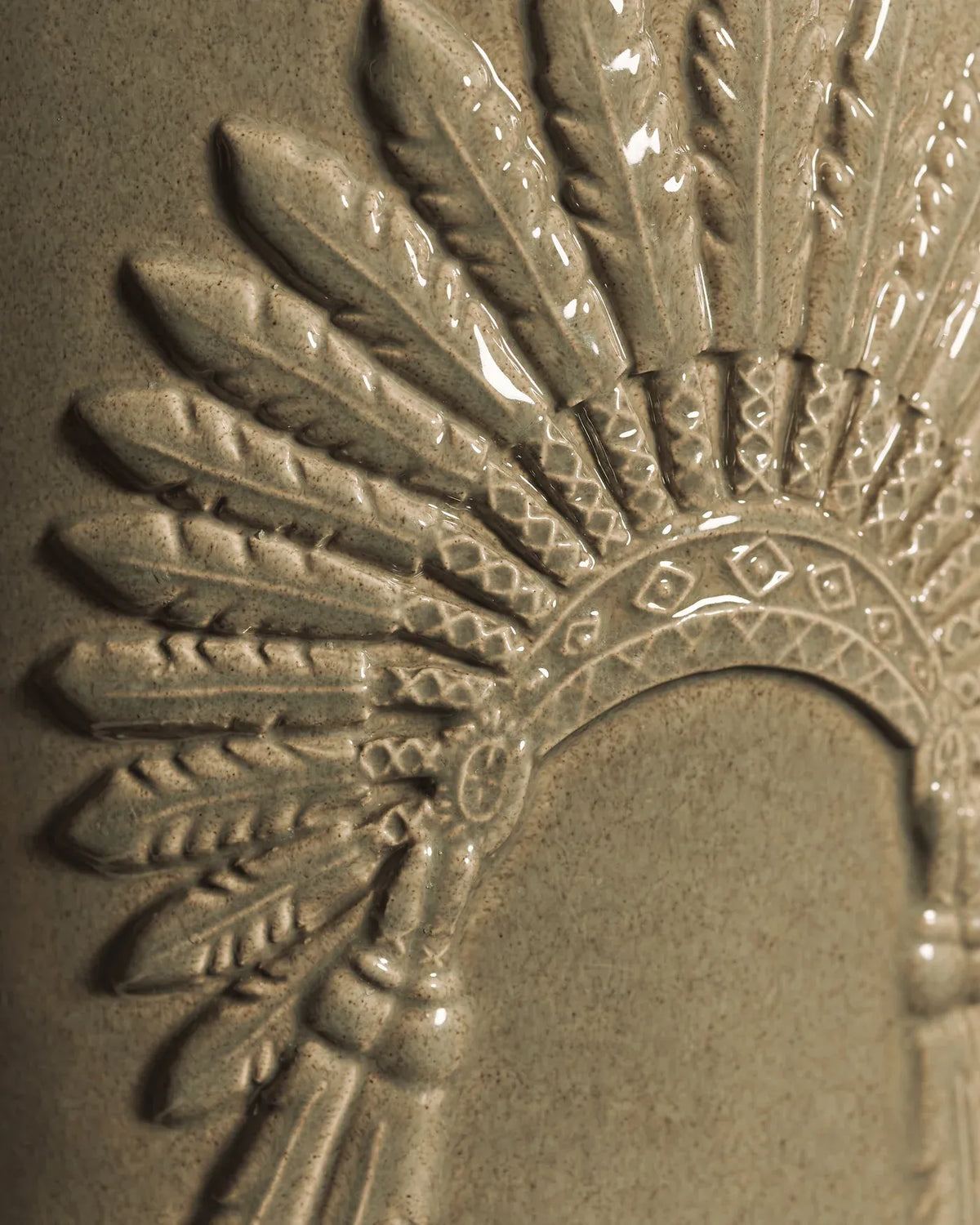 Détail de la coiffe en relief sur la céramique gris minéral de la bougie Crazy Horse Baobab Collection