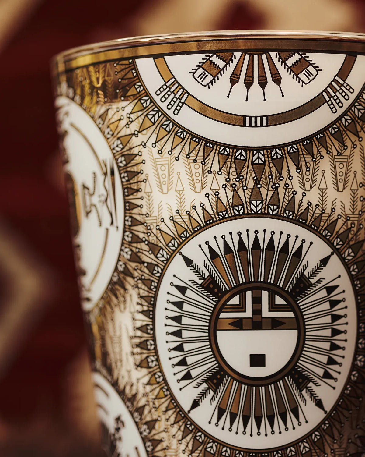 Détail des motifs géométriques noirs et dorés sérigraphiés sur le verre de la bougie Likááh Baobab Collection