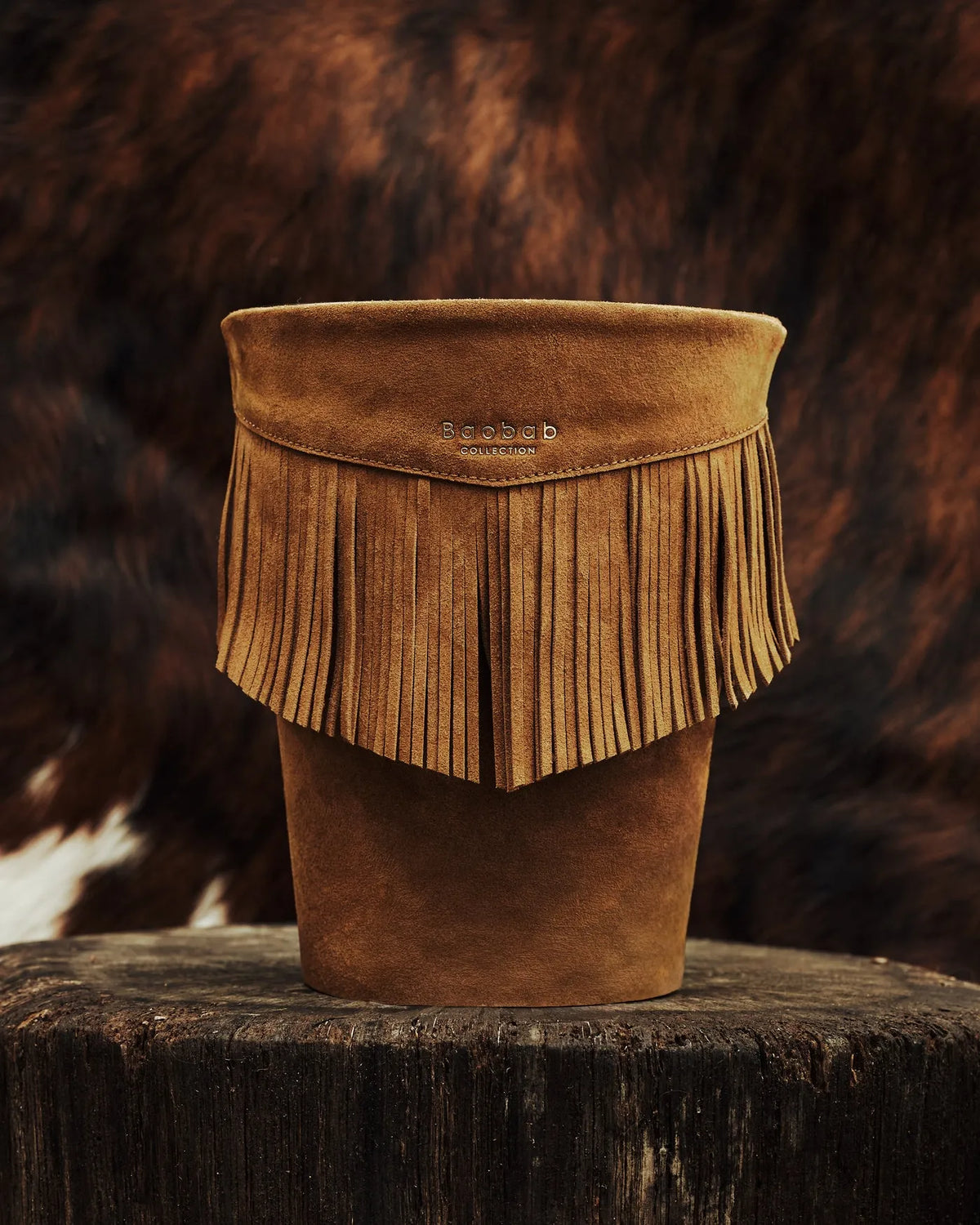 Bougie Wild Bill Baobab Collection en cuir cognac à franges dans une mise en scène inspirée du western