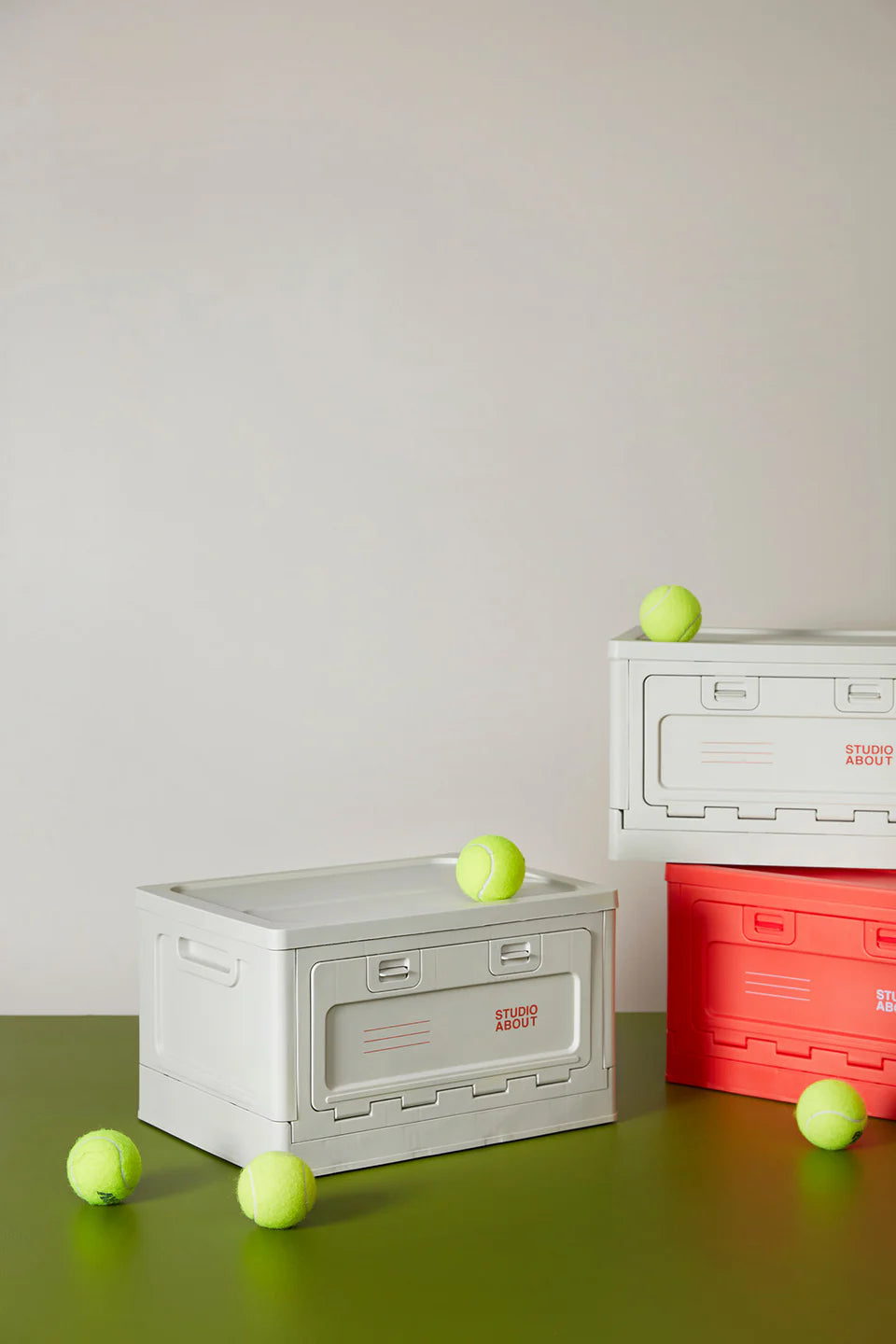 Boites de rangement Studio About grise et rouge avec des balles de tennis autour