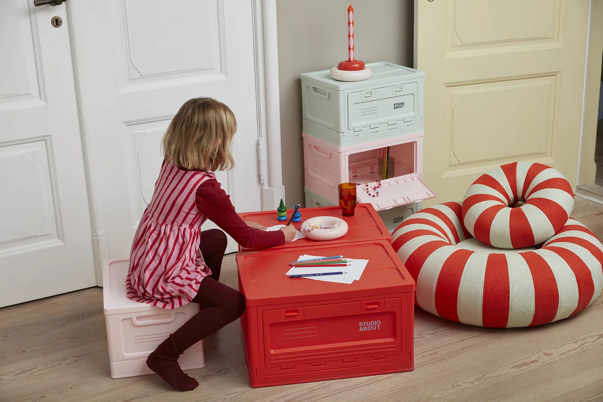 BOX Medium Rose Studio About utilisée comme assise par un enfant dans un intérieur