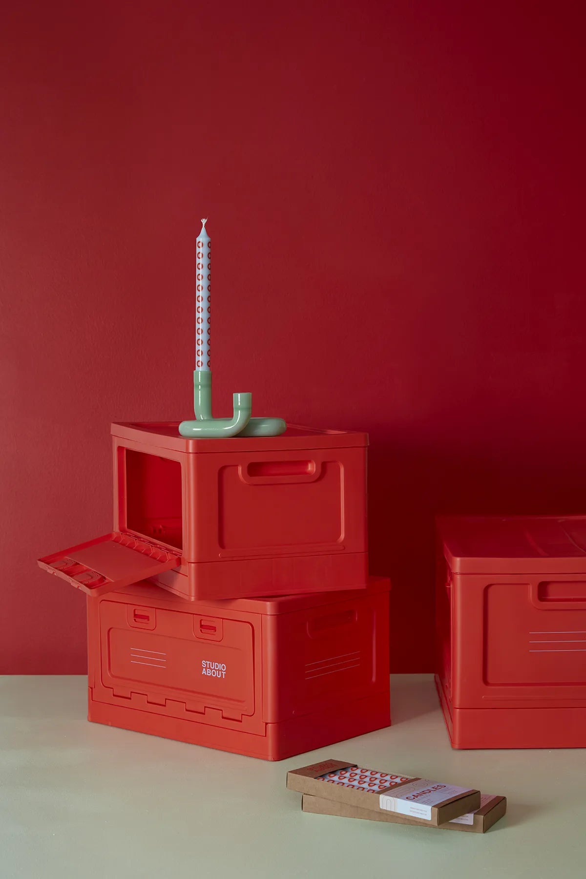 BOX Rouge Studio About intégrée à une décoration avec bougeoir et chandelles