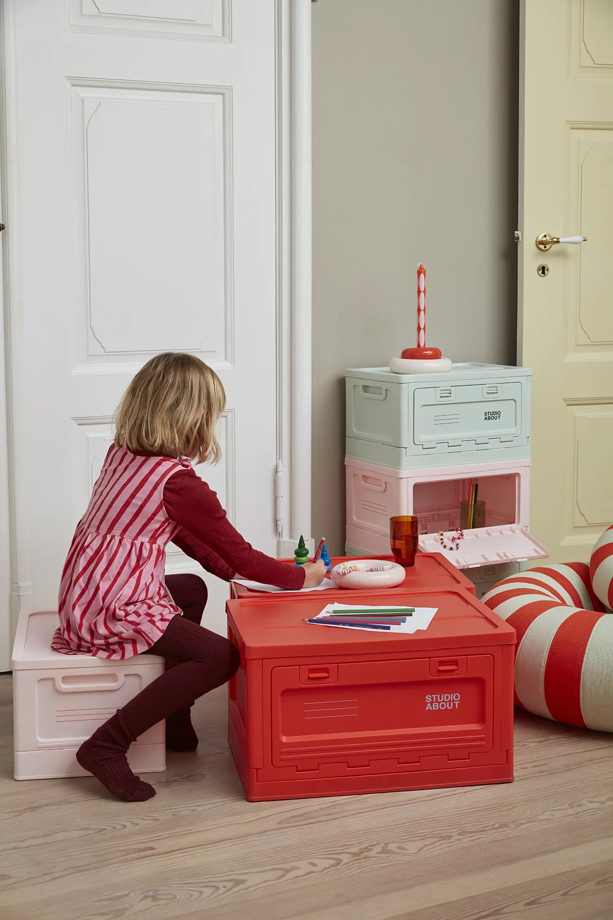 BOX Rouge Studio About utilisée comme table pour enfant et rangement dans un intérieur
