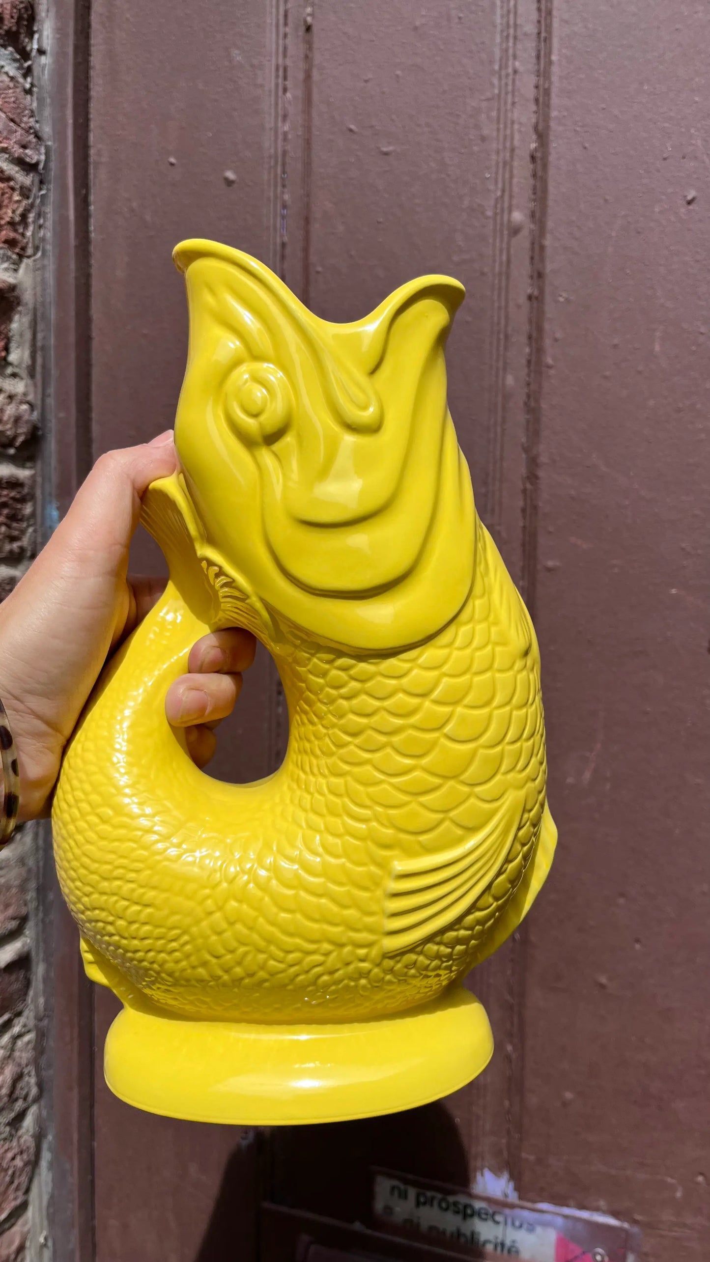 Carafe GlouGlou Jaune devant une porte en extérieur