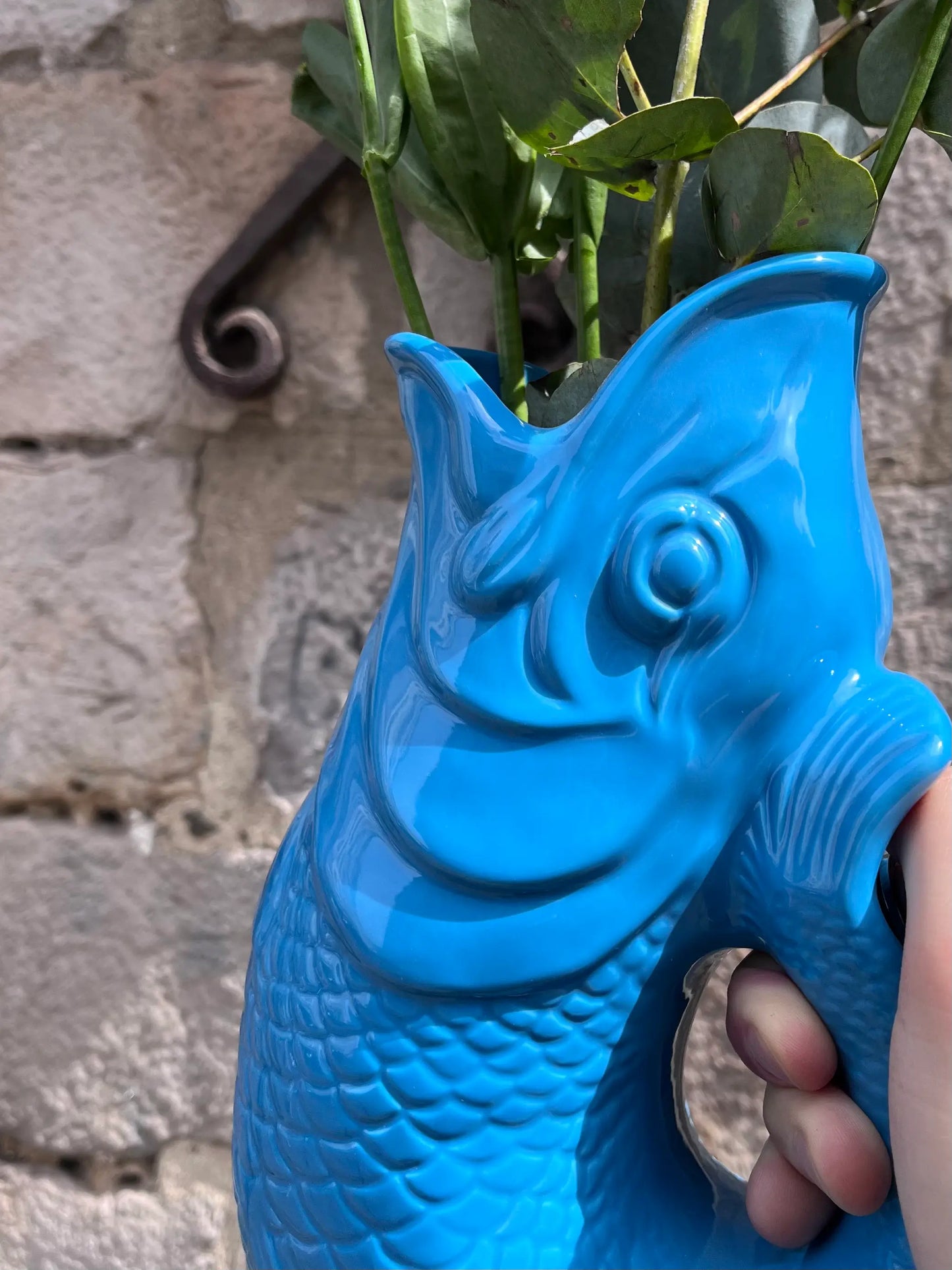 Vase Glouglou turquoise avec des fleurs en extérieur