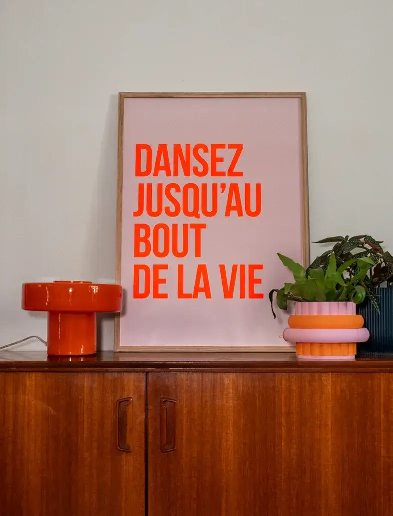 Affiche "Dansez jusqu'au bout de la vie" en orange fluo sur fond rose.