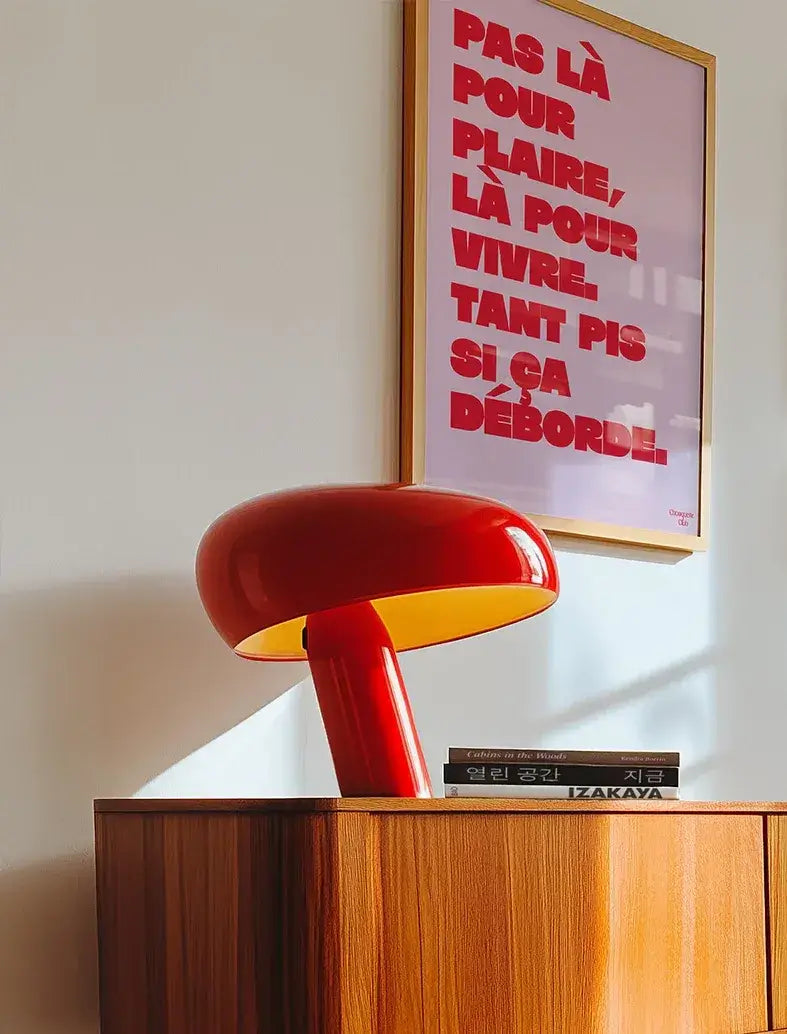 Affiche "Pas pour là pour plaire" en rouge sur fond rose.