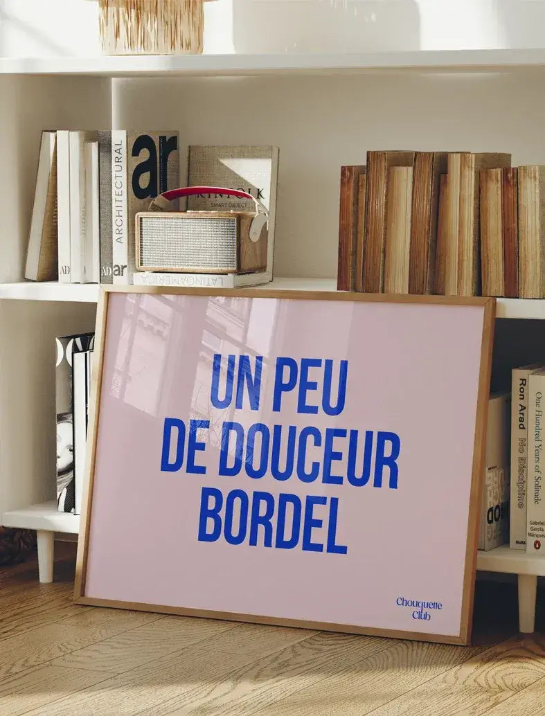 Affiche "Un peu de douceur bordel" en bleu électrique sur fond rose.