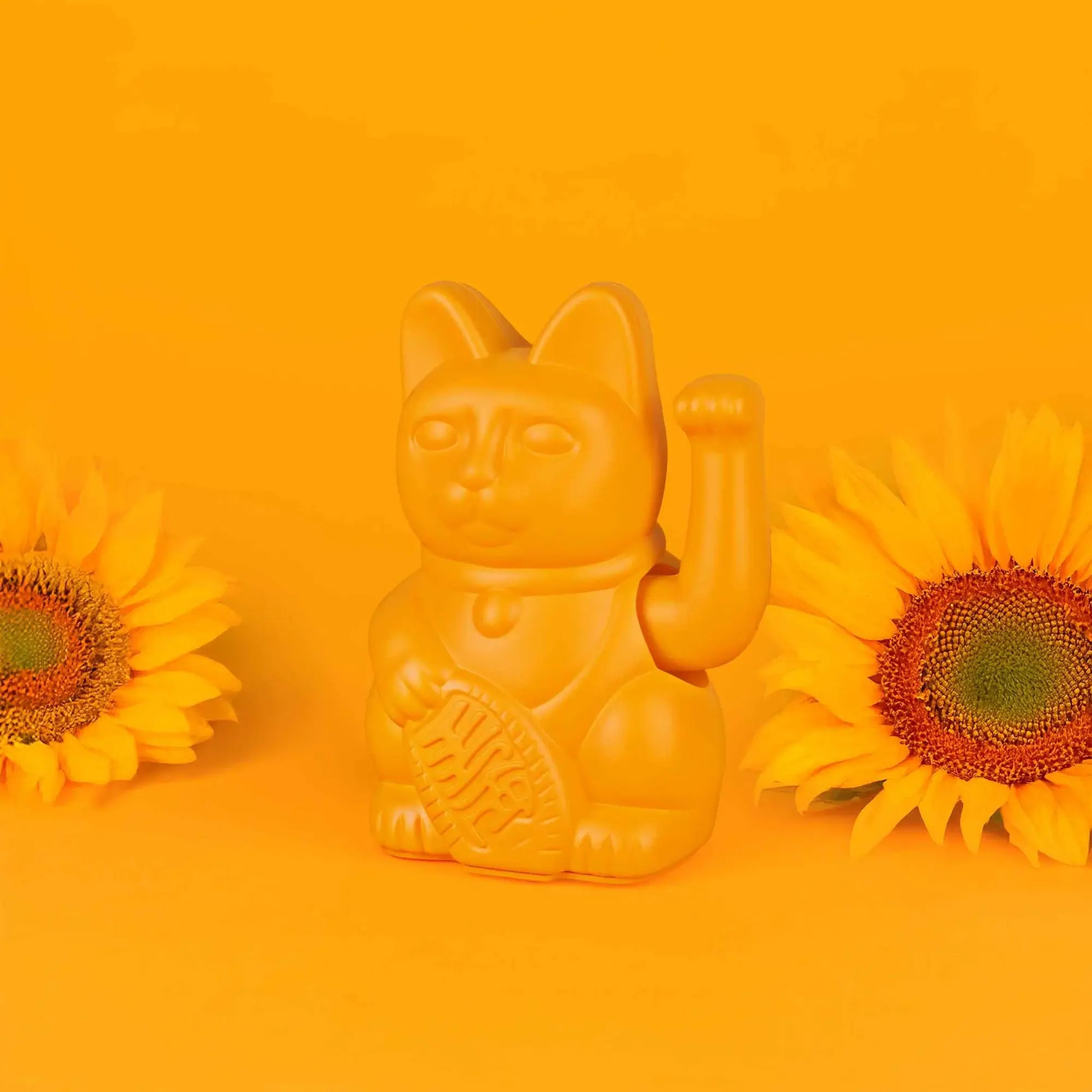 Maneki Neko (Lucky Cat) Jaune Profond par Donkey sur un fond coloré avec des fleurs de tournesol