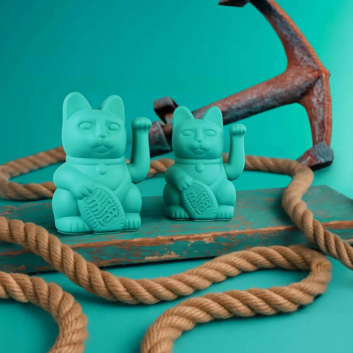 Maneki Neko (Lucky Cat) Turquoisepar Donkey sur un fond coloré avec une ancre, une corde d'amarrage et une blanche bleue. De quoi nous rappeler la côte, la mer et les parties de pêche.