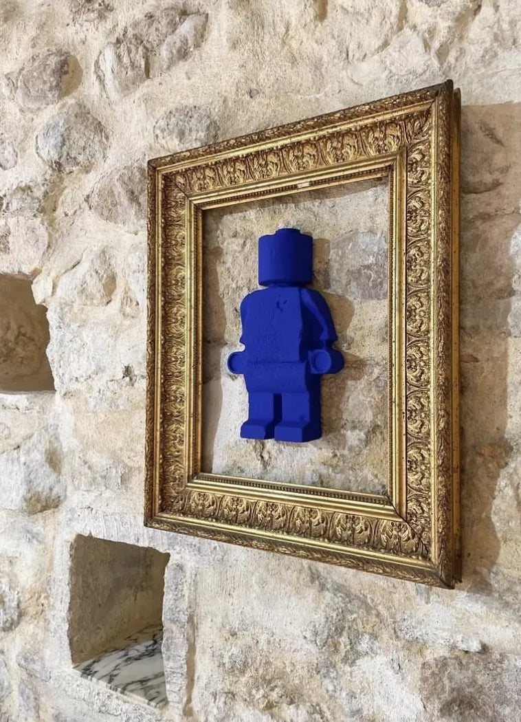 Donneur d'amour bleu Klein 20cm présenté sur un mur en pierre avec Marie Louise dorée