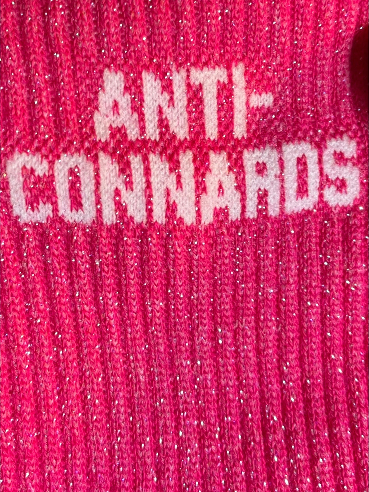 Focus sur la chaussette Félicie cousue en coton, rose à paillettes avec « anti-connards » écrit en blanc