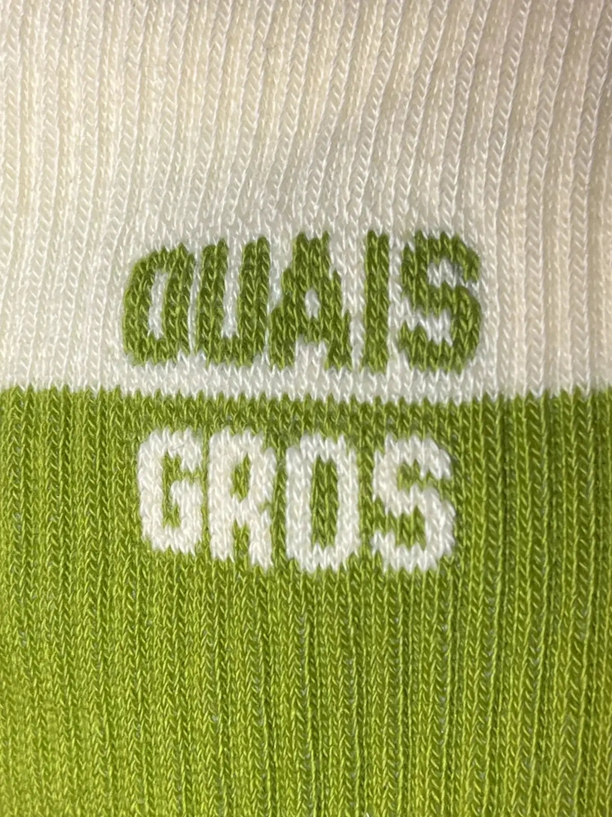 Focus sur la chaussette Félicie cousue en coton, vert et blanc avec « ouais gros » écrit en blanc