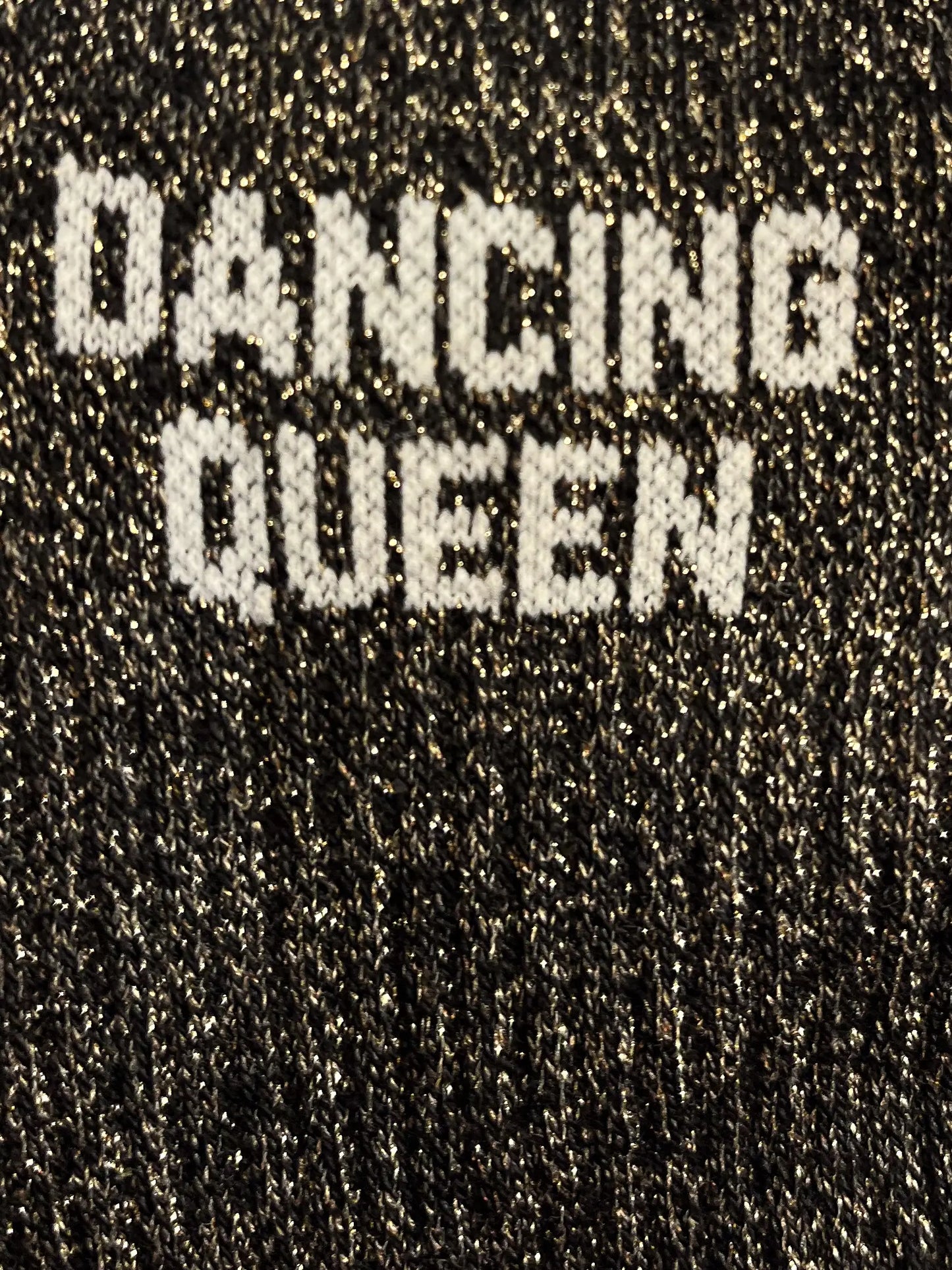 Focus sur la chaussette Félicie cousue en coton, noire à paillettes avec « dancing queen » écris en blanc