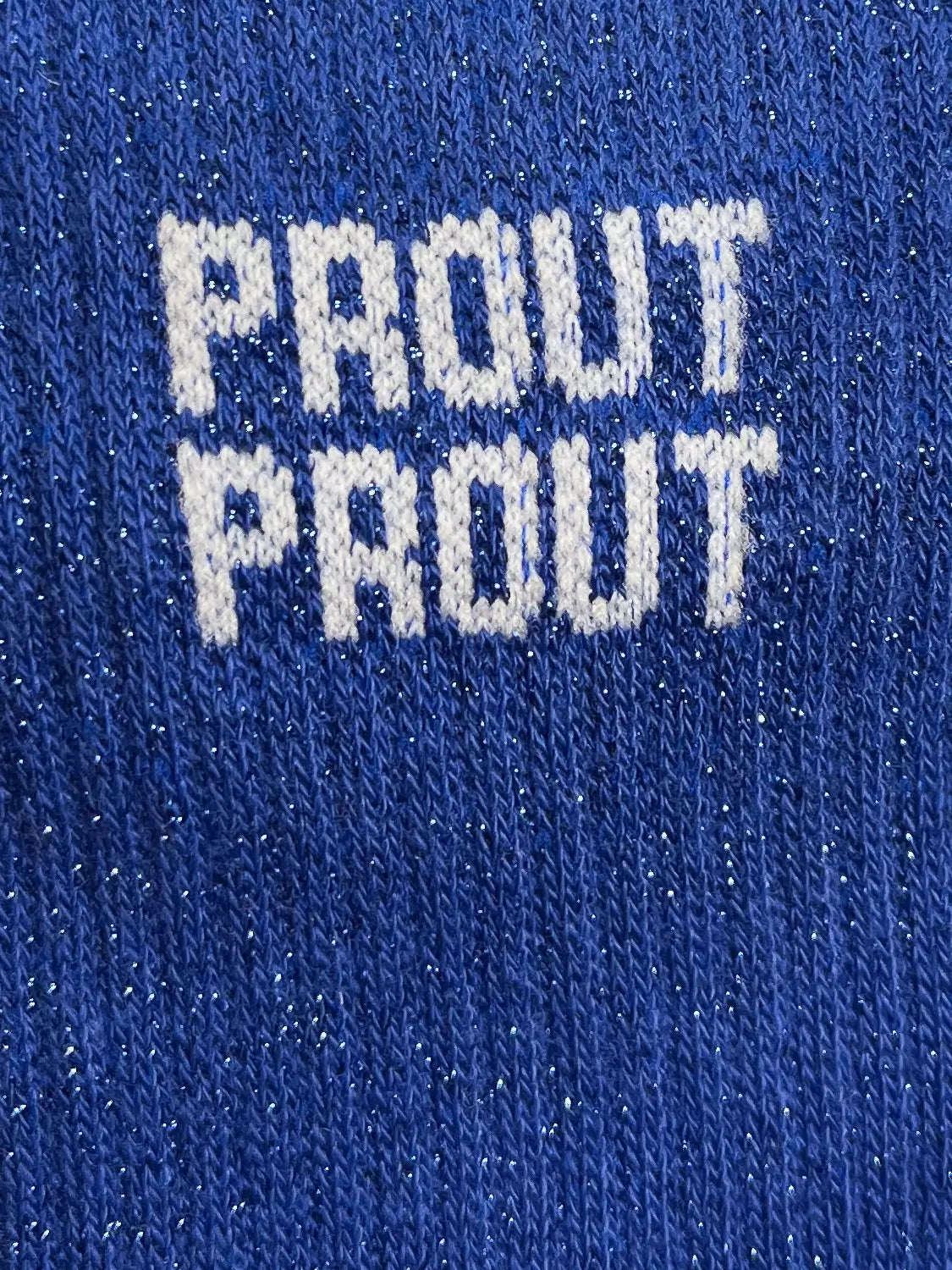 Focus sur la chaussette Félicie cousue en coton, bleue foncée à paillettes avec « Prout Prout » écris en blanc