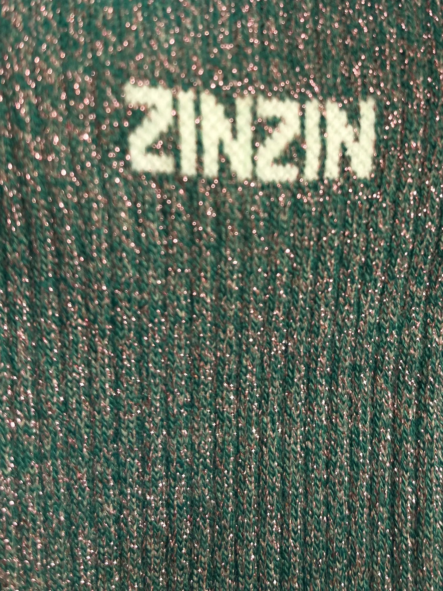 Focus sur la chaussette Félicie cousue en coton, couleur verte à paillettes avec « Zinzin » écris en blanc
