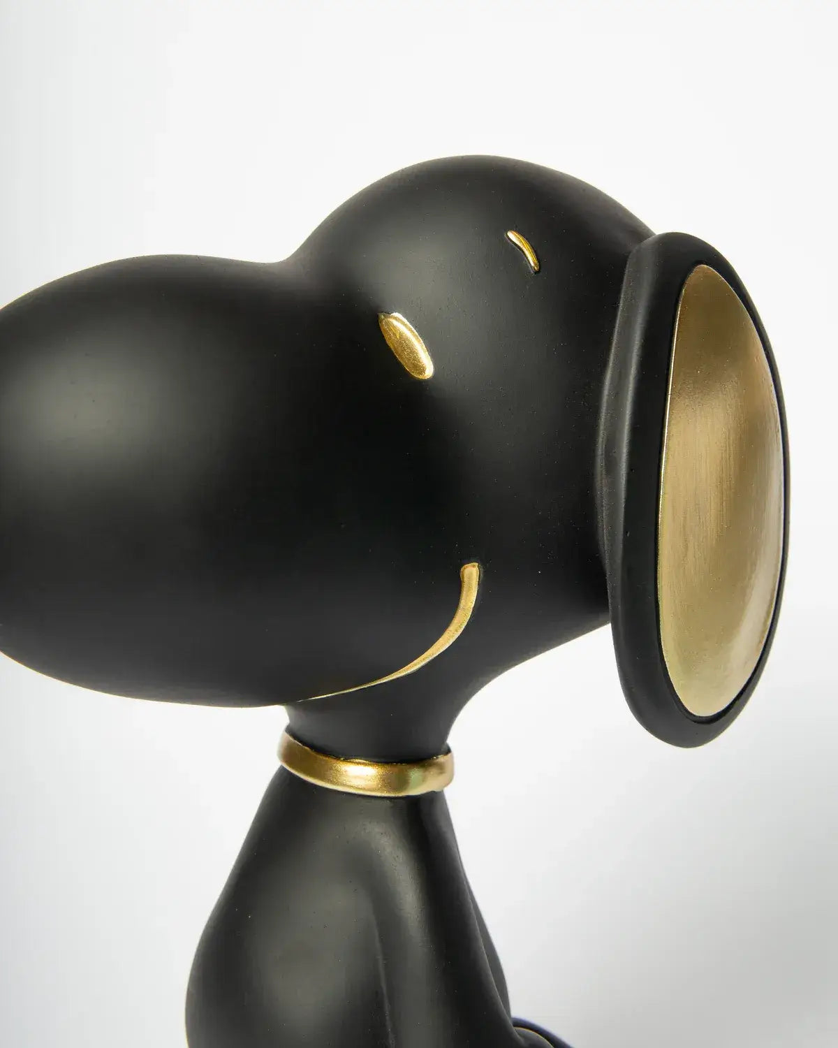 Détails dorés du visage de la figurine Snoopy noir