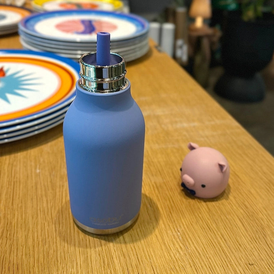 Gourde en inox Asobu Cochon recouverte de silicone mauve sur une table
