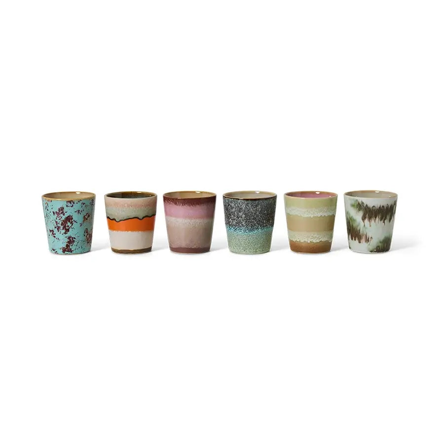 Tasses à café Surreal alignées sur fond blanc