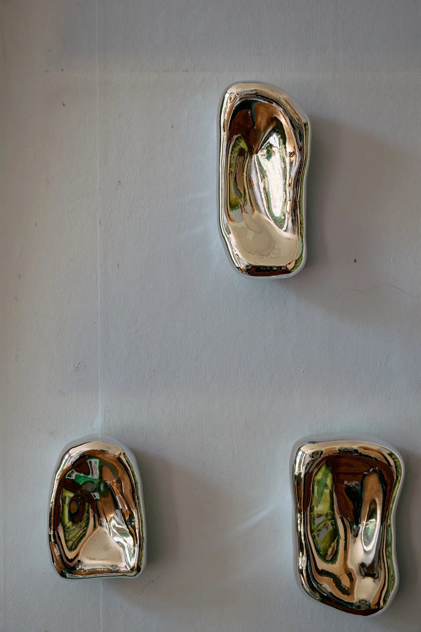 Trois sculptures Murales en verre chromé par HKLiving accrochées à un mur
