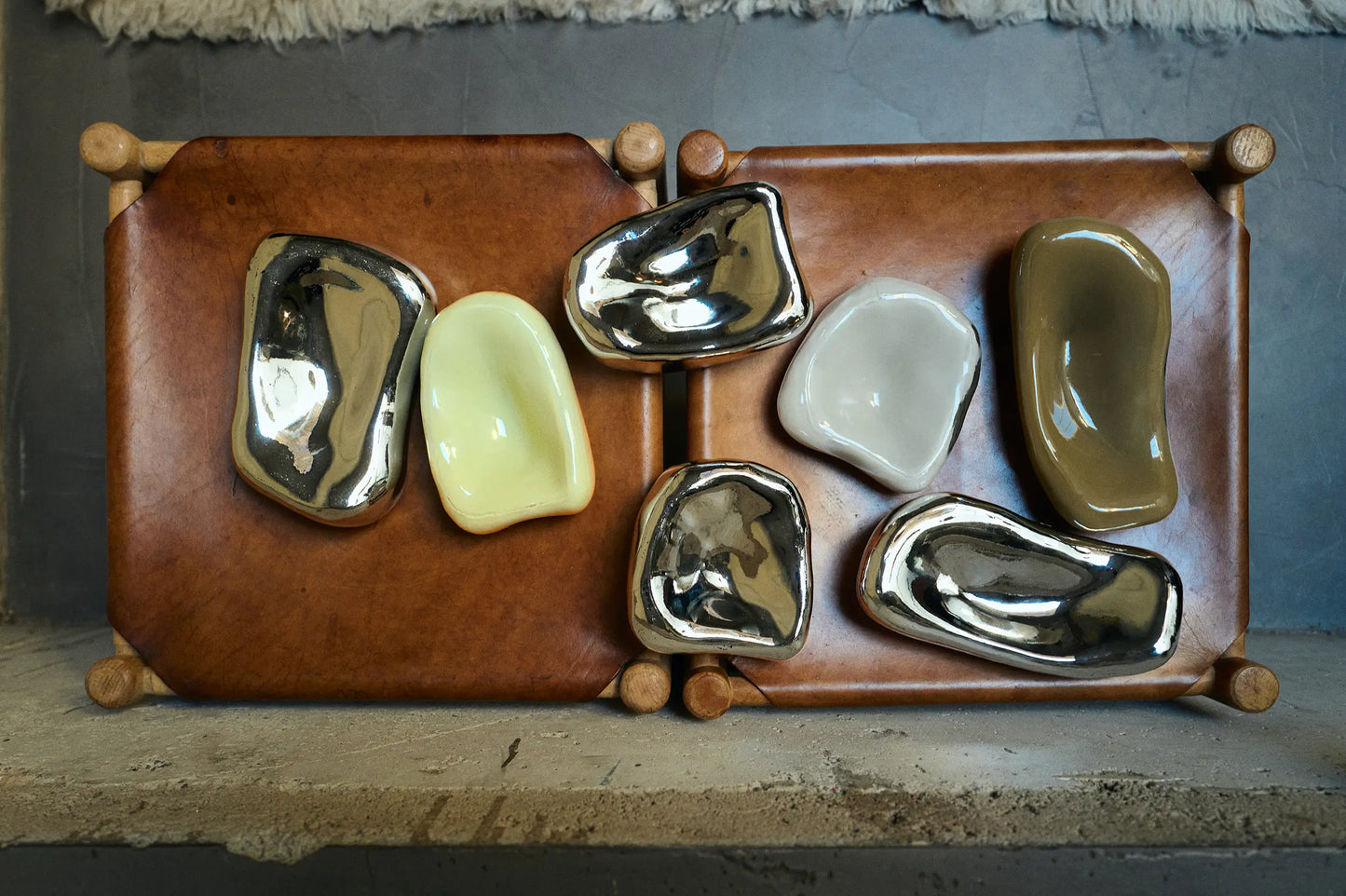 Les sculptures Murales en verre chromé par HKLiving posées sur une étagère