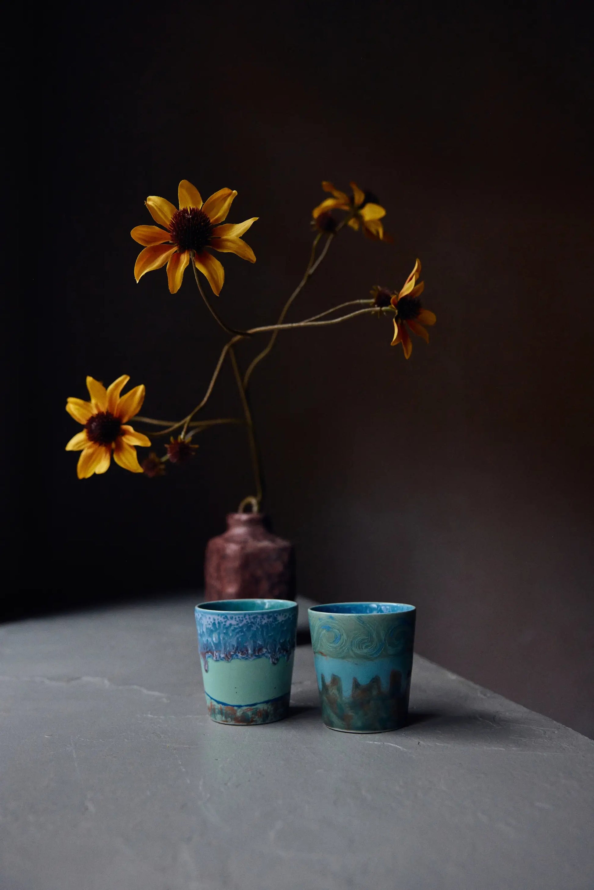 Tasses à café Van Gogh Self Portrait à côté d'un pot de fleurs jaunes