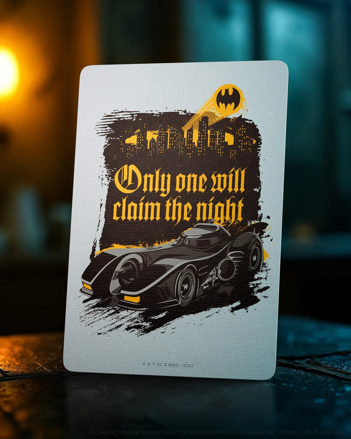 Carte décorative de la Batmobile, du bat-symbole et la mention "Only one will claim the night"
