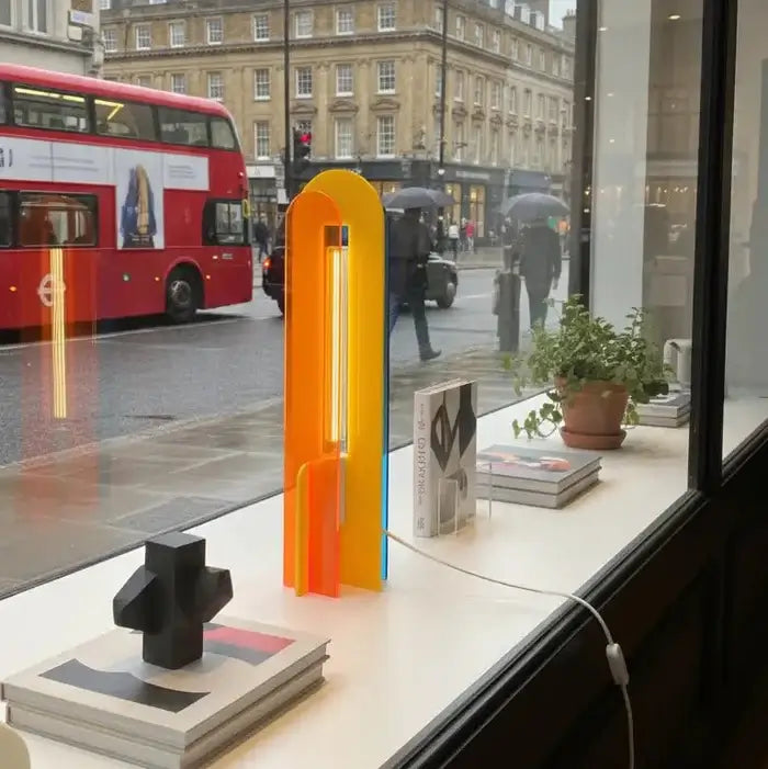 Lampe Andy bleu, jaune et orange dans une vitrine