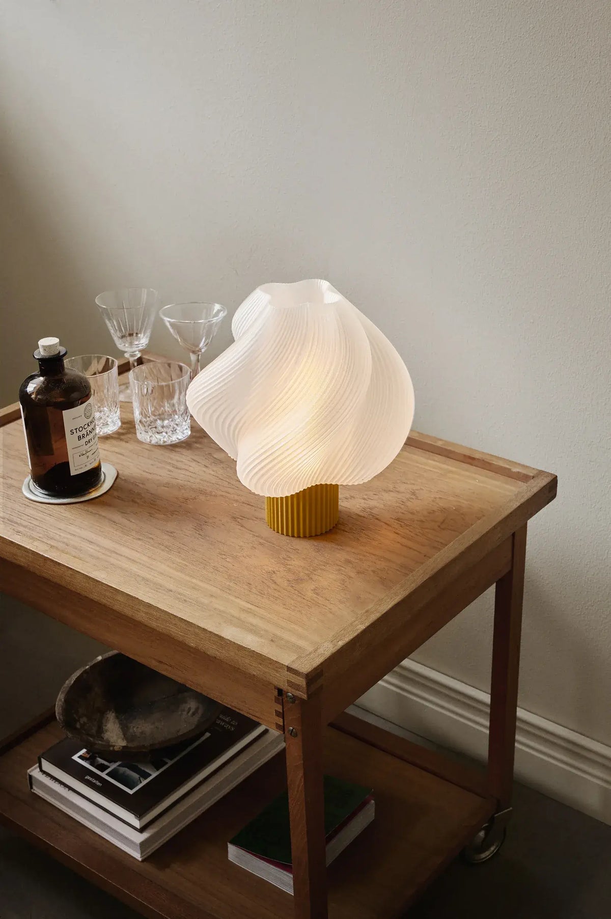 Lampe de table Soft Serve Cloudberry allumée sur une table en bois